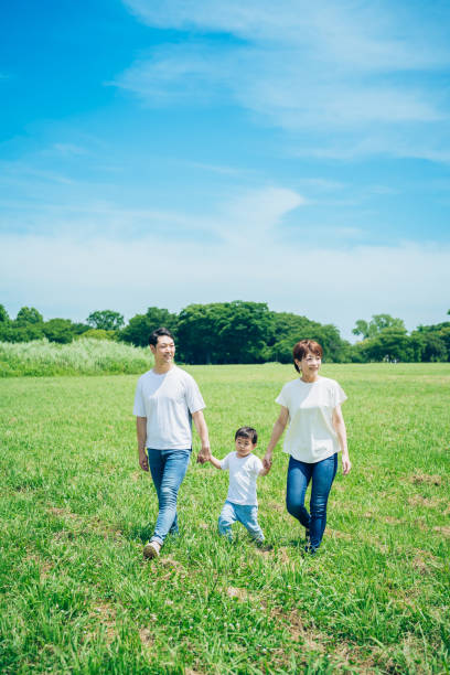 istock Parents and their child walking on a sunny green space 1409567485