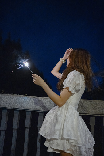 Asian girls playing fireworks at night