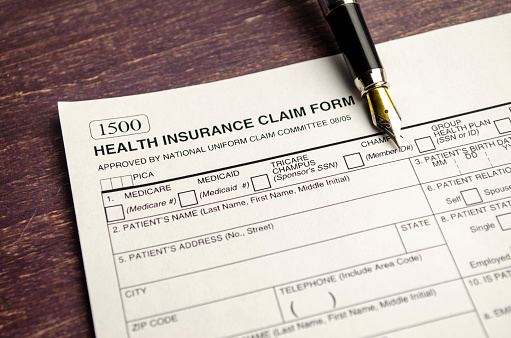 health insurance form with pen on wooden background