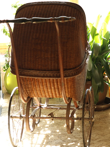 Side view of a vintage baby pram isolated on a white background