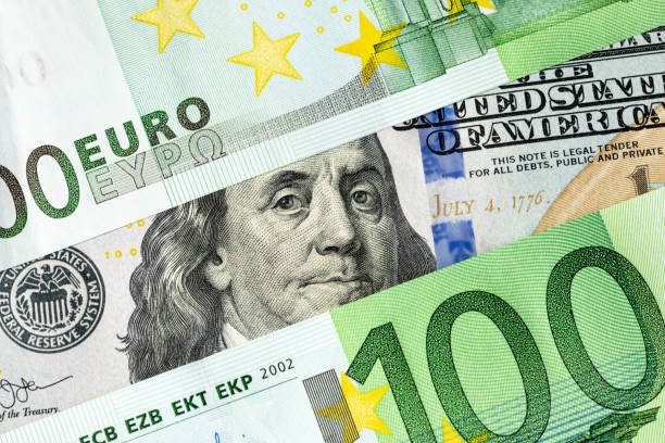 franklin from a 100 us dollar banknote looks out between two 100 euro banknotes. the relationship between europe and america, america's influence on the european union concept - todas as unidades monetárias europeias imagens e fotografias de stock