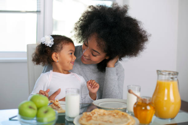 istock African-American young mother and daughter having breakfast 1409585400