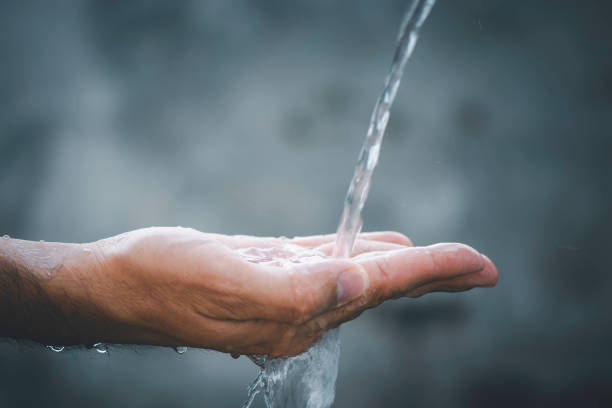 istock Hands with water splash, in man hand on elegant black background 1409586424