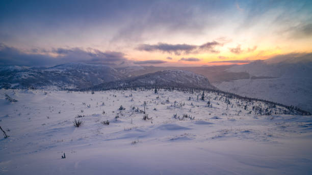ciel coloré et soleil alors que le soleil se couche sous l’horizon, sur les montagnes enneigées de gaspésie - frozen ice sky sun photos et images de collection
