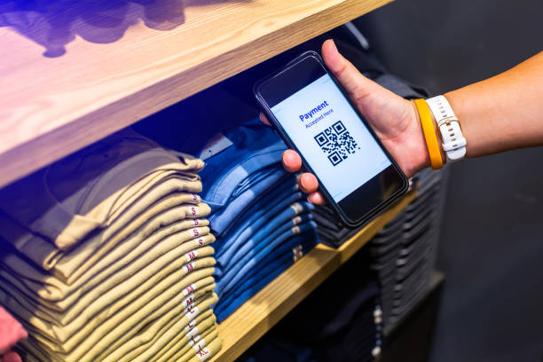 istock Customer hand using smart phone to scan QR code tag with many row of clothes  to accepted generate digital pay 1409594240