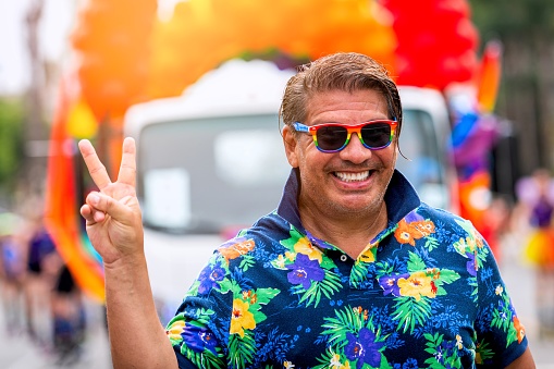 Smiling mature gay man posing looking at the camera at the pride parade