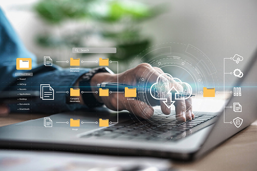 A businessman using a computer to manage documents shows a cloud computing diagram. online document database and future technology ideas Information Document Management System (DMS) Network Concept