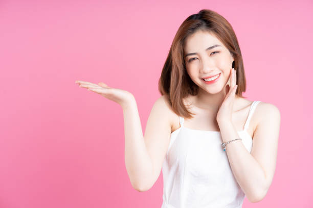 istock Image of young Asian woman posing on pink background 1409596580
