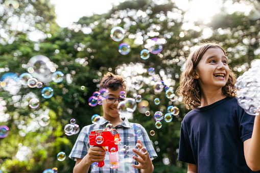 Boys playing with soap bubbles in the public park