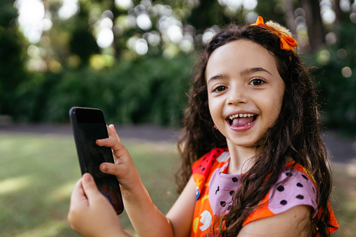 Smiling girl holding smartphone