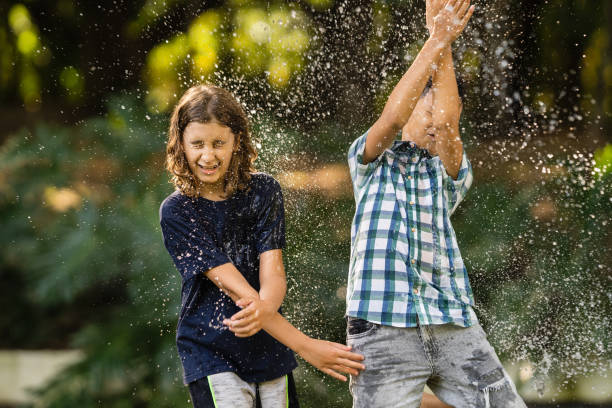 istock Boys playing with water in the public park 1409599751