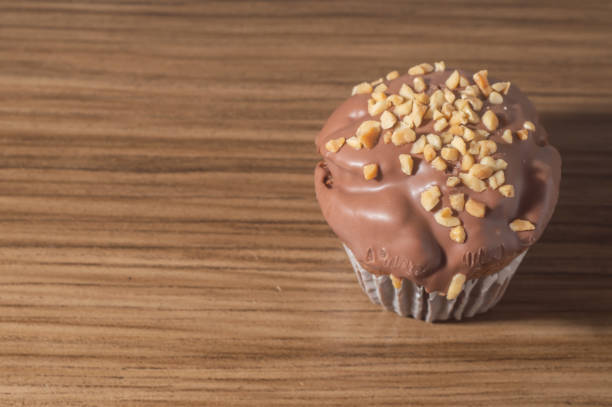 Chocolate cupcake, chocolate muffin with chestnuts, on a wooden table with copy space.