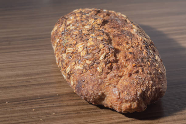 istock Whole wheat rye bread slice with seeds, multigrain bread on a wooden table with copy space 1409601945