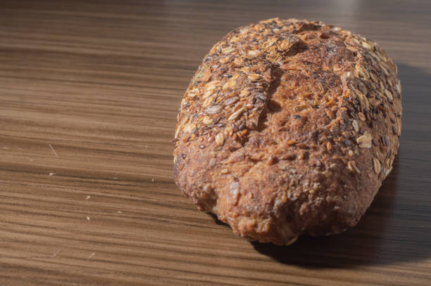 Whole wheat rye bread slice with seeds, multigrain bread on a wooden table with copy space.