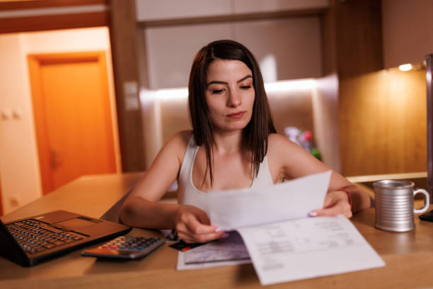 istock Young woman doing her accounts at home 1409602311