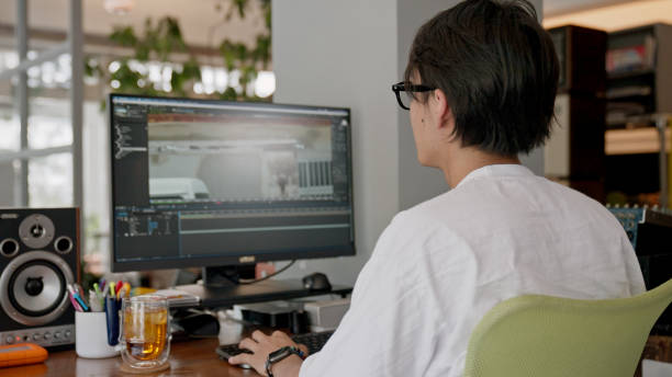 BS, Japanese young man editing video at the office.
