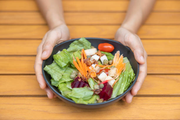 istock Woman's hand holding vegetable salad and eating Breakfast 1409604352