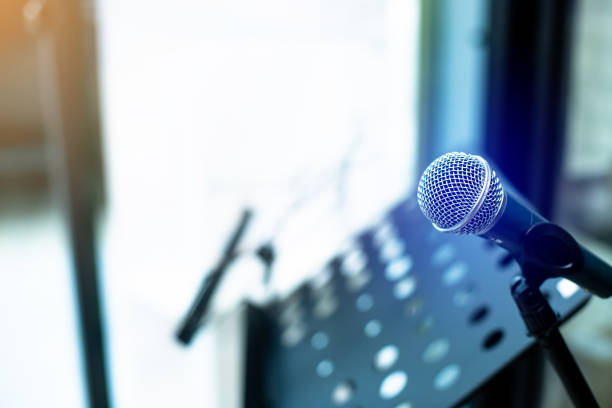 istock Microphone with blurry musician's lectern or music stand in music studio. 1409604543