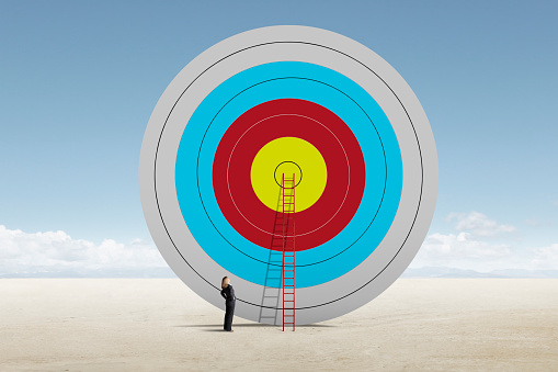 Three darts hitting the center of a target over orange background. Business success concept image.