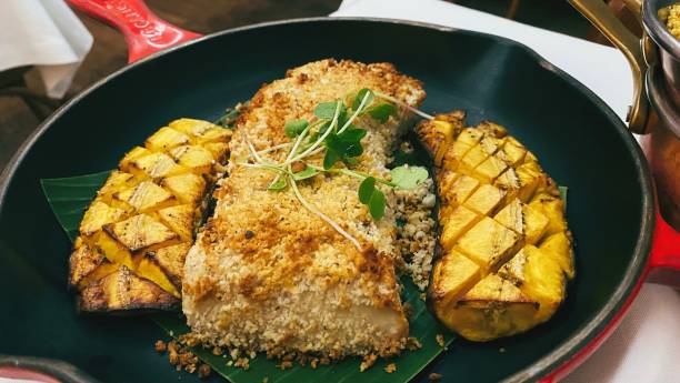 Amazonian Pirarucu fish with crumbled nuts and toasted banana