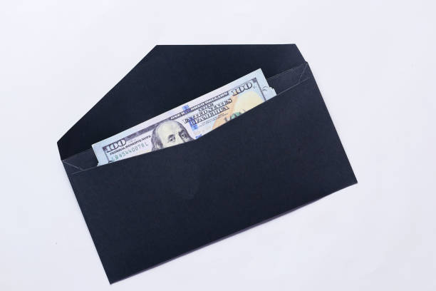istock 100 dollar cash in a envelope on a desk 1409609451