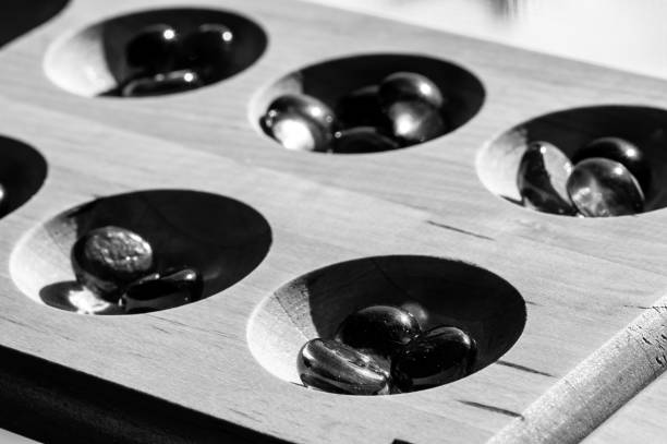 istock Selective focus on glass beads on a wooden mancala board 1409610546
