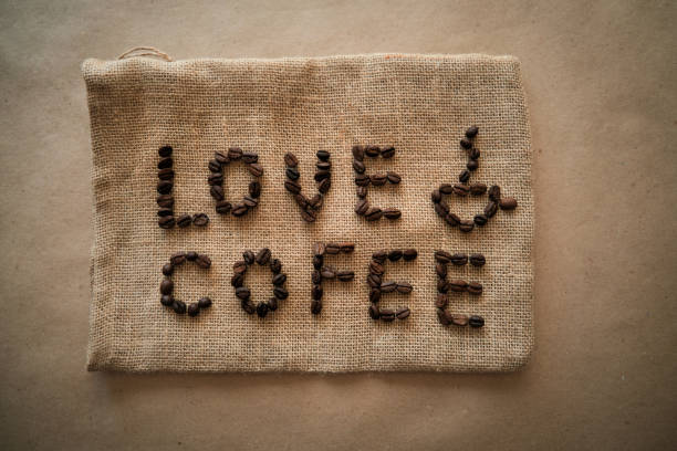 istock Inscription love coffee from coffee beans on burlap background. 1409612722