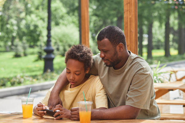 istock Boy playing game on smartphone with his dad 1409614635