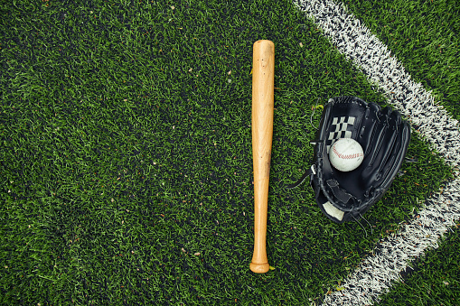 Close up image of a baseball player sliding during a baseball game. The opposite team player tags him with his glove. Players are wearing unbranded generic baseball uniform. The game takes place on outdoor baseball stadium full of spectators under stormy evening sky at sunset. The stadium is made in 3D.