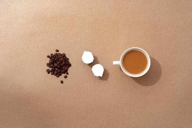 istock Cup of coffee with coffee beans on paper background. Top view 1409623687