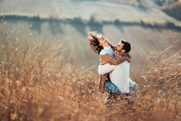istock Young happy couple having fun while playing in autumn day on a hill. 1409625157