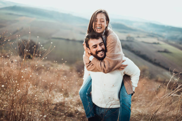 istock Young cheerful couple having fun while piggybacking on a hill. 1409625242