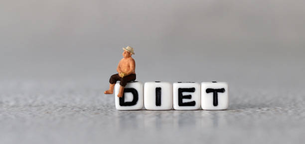 istock White cube arranged in the word  ’DIET' with miniature people. 1409629444