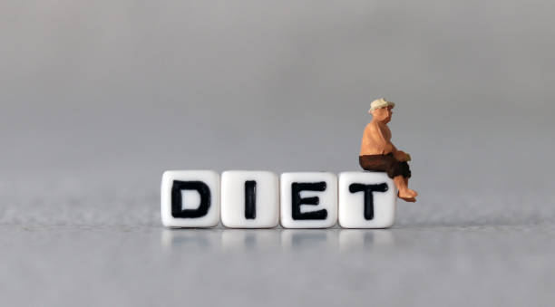 istock White cube arranged in the word  ’DIET' with miniature people. 1409629448