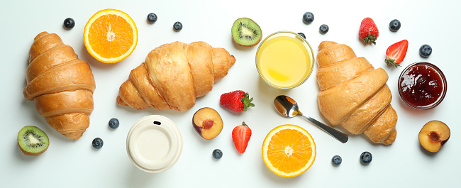 Concept of tasty breakfast with croissants on white background