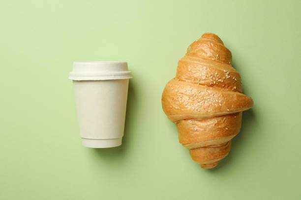 istock Croissant and paper cup on green background 1409631202