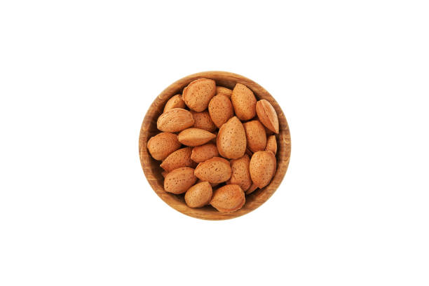 istock Dried almonds in a shell on wooden plate top view. White background, copy space. Design element, template 1409636183