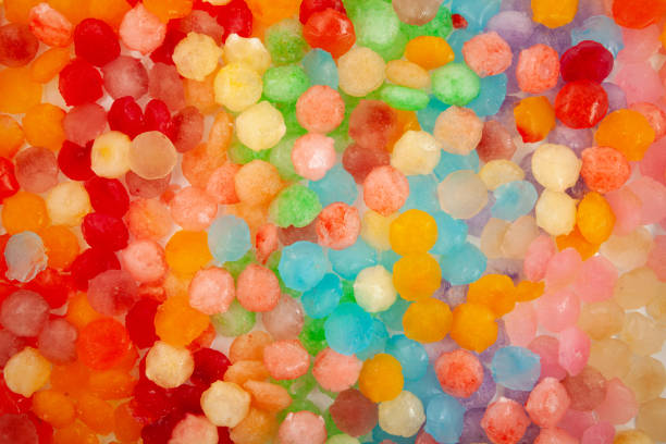 istock Frozen fruit juice. Rainbow ice for cocktail or summer refreshing drinks. Colored ice cubes, close-up. Design element 1409636250