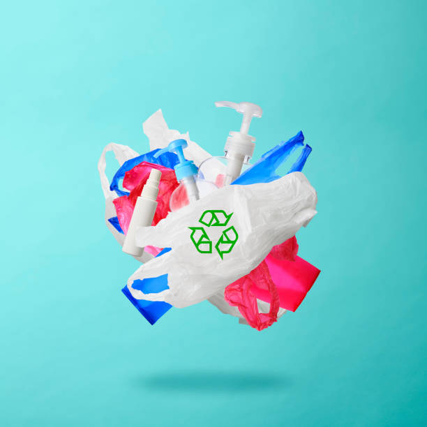 Close-up of Plastic garbages with recycling symbol floating in mid-air against light blue background.\nConcepts of environmental and recycling.