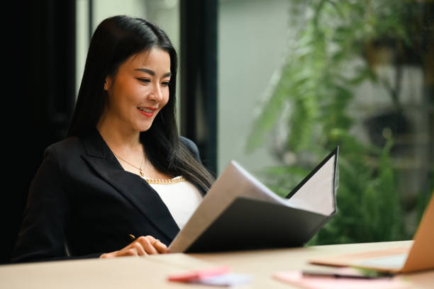 istock Smiling female manager checking financial report or correspondence at her workplace. 1409642445