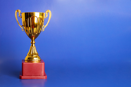 award cup, trophy prize on blue background, copy space