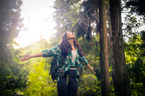 Happy woman enjoying life in forest