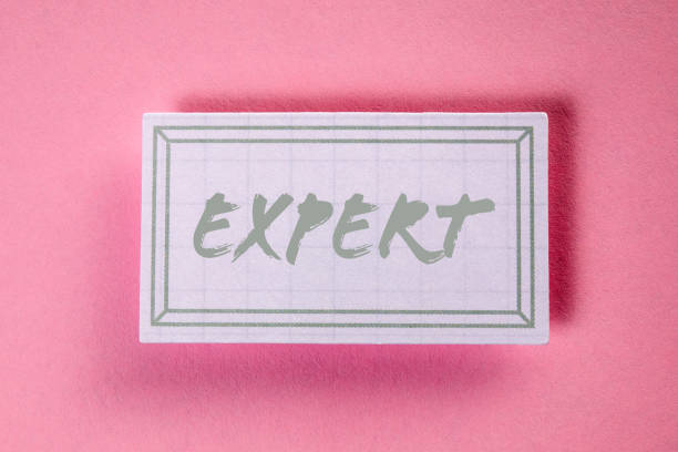 istock EXPERT. Text on a checkered piece of paper. Pink background 1409646293