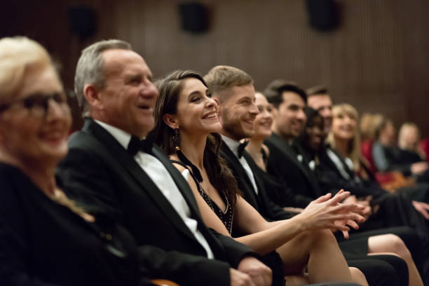 istock Smiling spectators sitting in the theater 1409649442