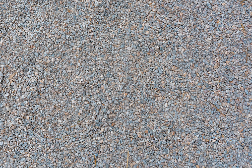 Texture of gravel stone used for farm driveway surface as background, top view