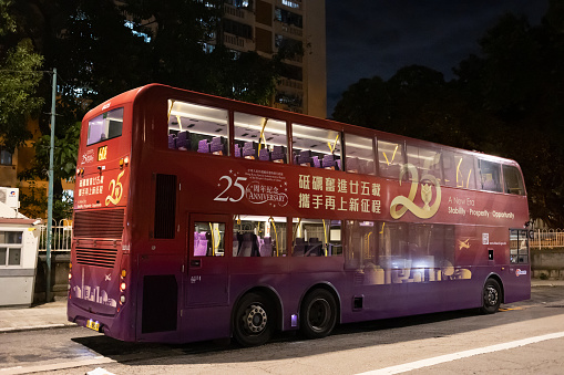 Hong Kong - July 14, 2022 : A bus featuring an advertisement celebrating the 25th anniversary of Hong Kong's handover from Britain to China.