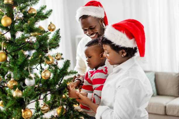 istock happy family decorating christmas tree at home 1409652328