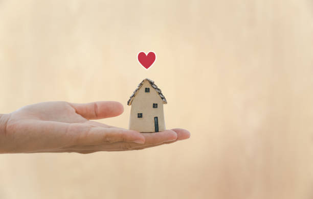 istock hand holding home model with heart 1409652709