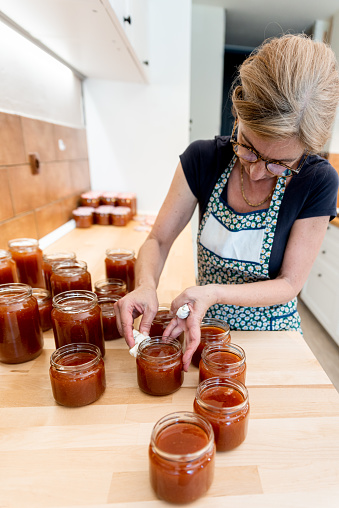Woman in Domestic Kitchen Canning in Jars Traditional Homemade Apricot Jam