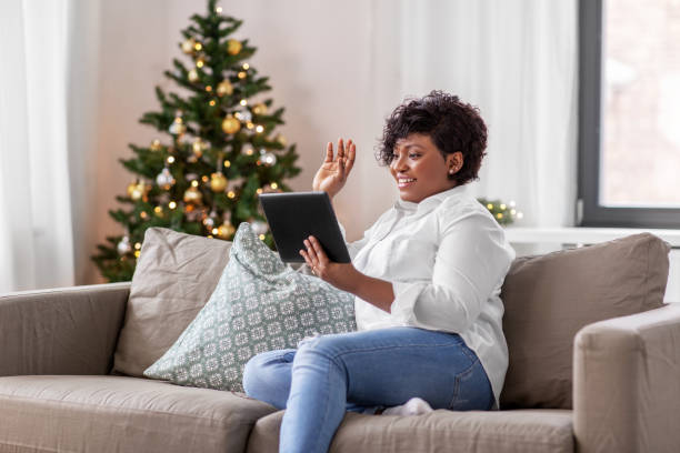 african woman with tablet pc at home on christmas stock photo